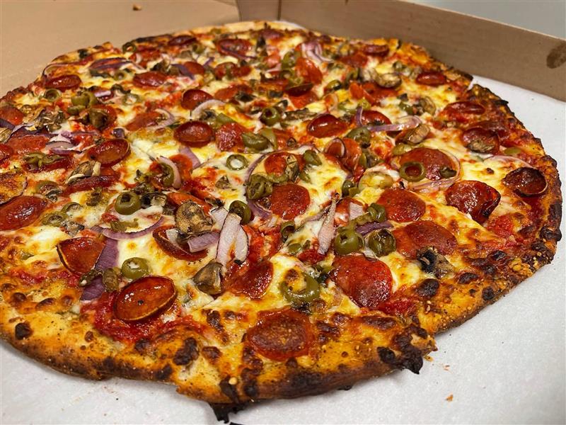 Pizza loaded with pepperoni, olives, red onion, and mushrooms