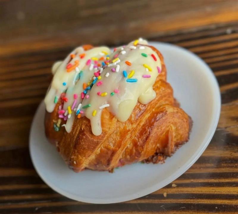 Iced croissant topped with rainbow sprinkles