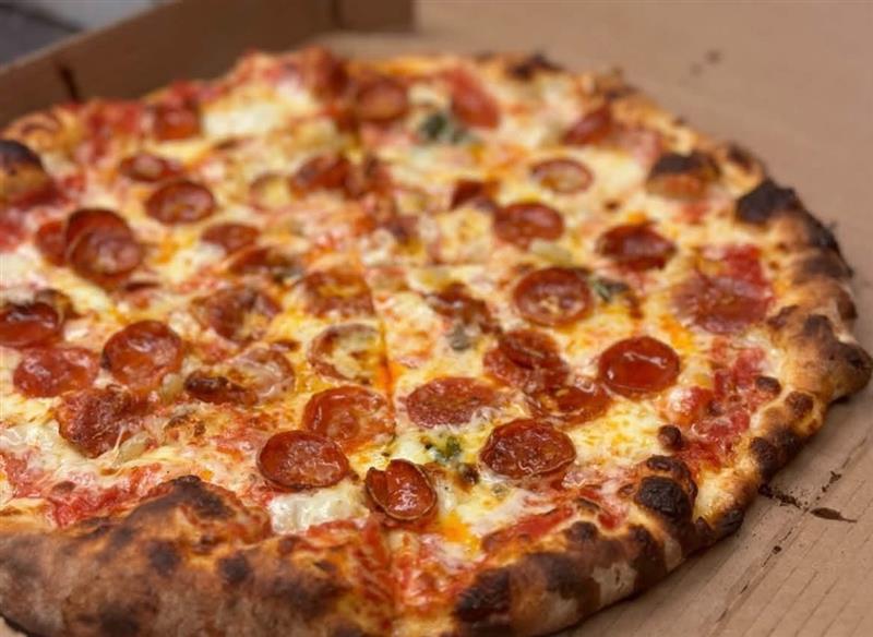 Wood-fired pepperoni pizza with a charred crust