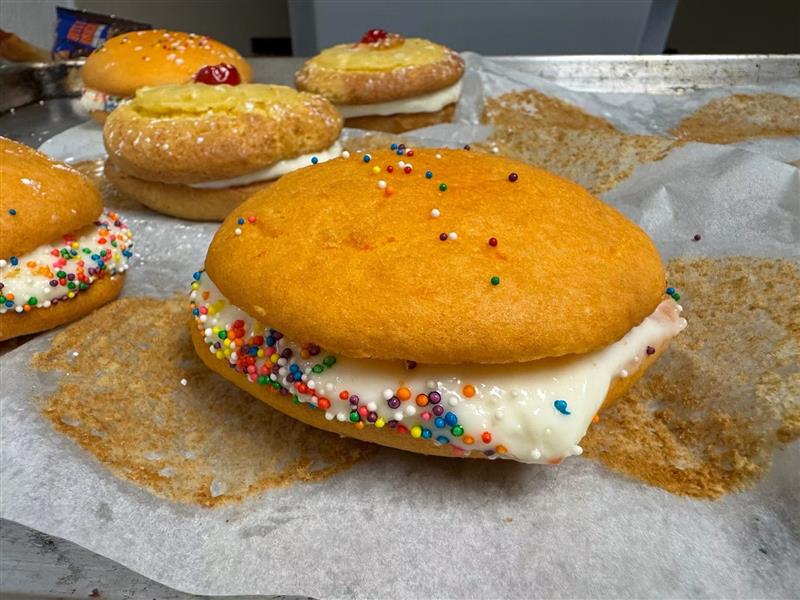 Whoopie pies with cream filling rolled in rainbow sprinkles